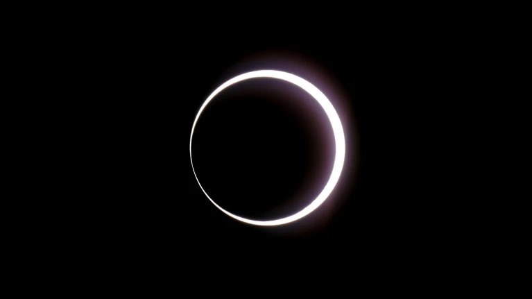 a black sky with a bright white ring in in the middle