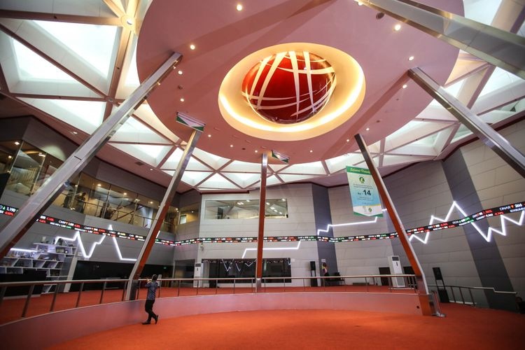 interior of a stock exchange building with a big circle on the ceiling and moving electronic graphic on the walls
