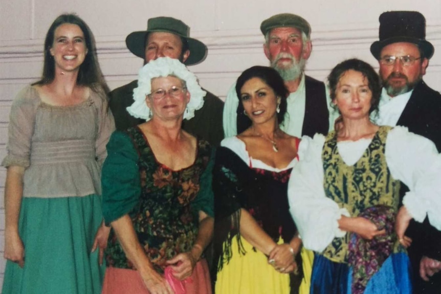 A group of people dressed up in period costumes for a stage production.
