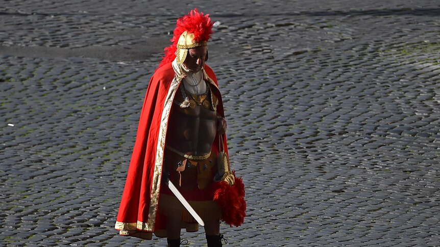 A man dressed as a Centurion waits for tourists