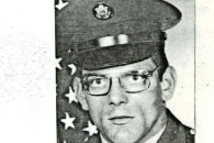 A young man in military uniform in a scanned black and white headshot 