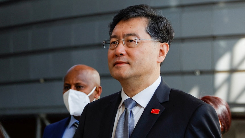 A Chinese man in a suit and glasses