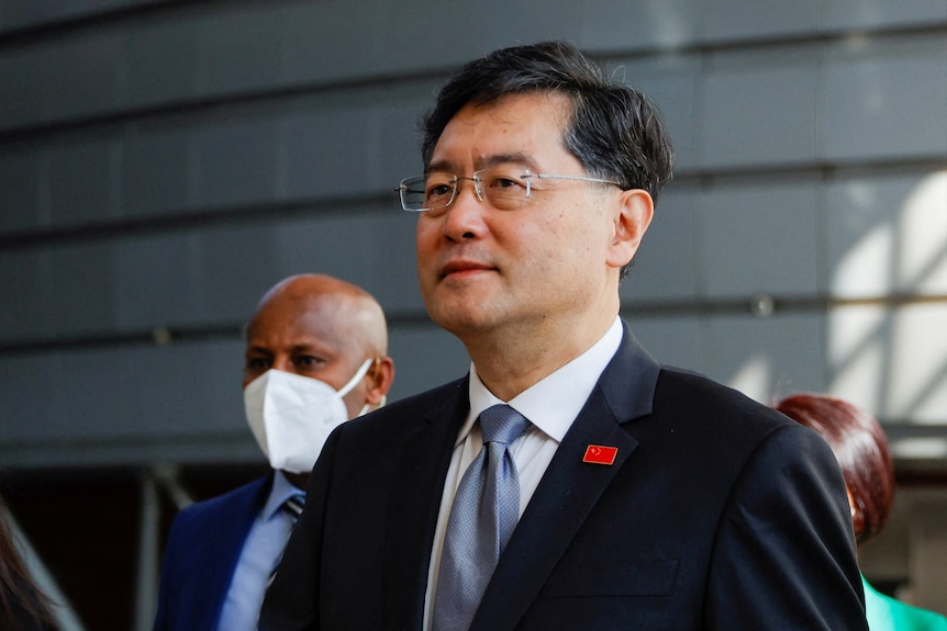 A Chinese man in a suit and glasses