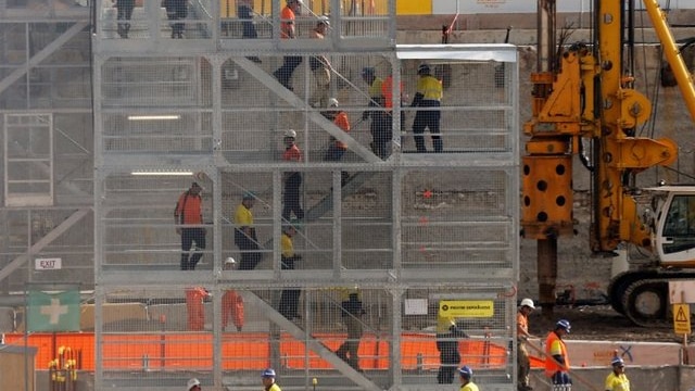 Construction workers descend using temporary stairs on a major construction site in central Sydney
