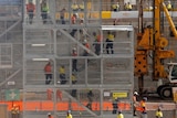 Construction workers descend using temporary stairs on a major construction site in central Sydney