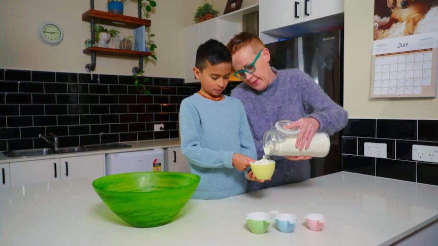 Mother and son pouring flour into a bowl