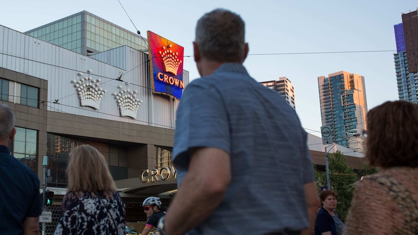 People walk past the entrance to Crown Casino.