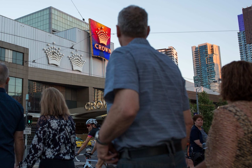 People walk past the entrance to Crown Casino.