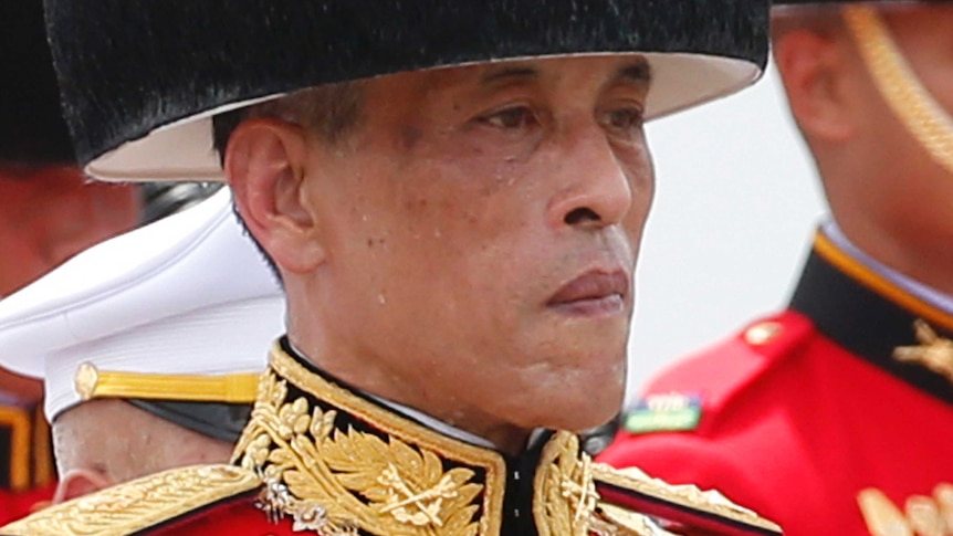 Thailand's King Maha Vajiralongkorn walks in a funeral procession of his father wearing military garb