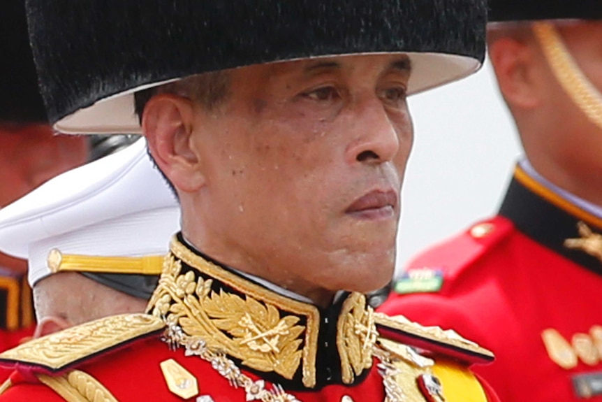 Thailand's King Maha Vajiralongkorn walks in a funeral procession of his father wearing military garb