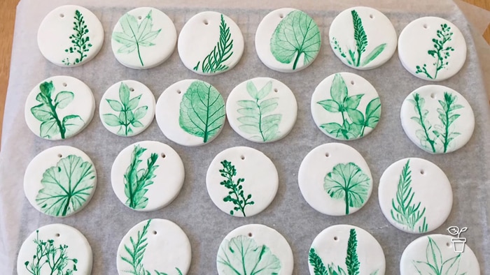 White clay circles with green leaf impressions pressed into them