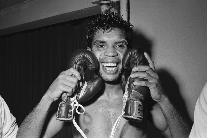 An archive photo of Lionel Rose holding up two boxing gloves in 1968.