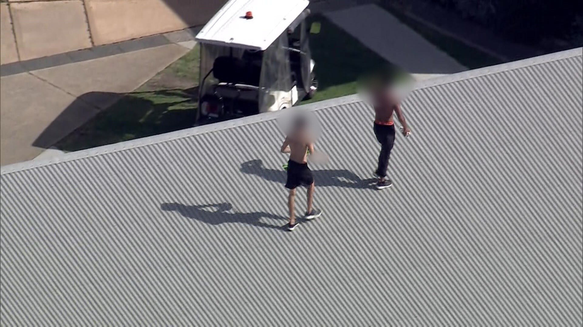 Dos niños pequeños en el tejado de un centro de detención.