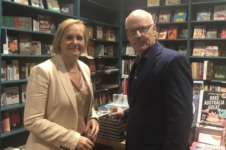 Lyons and Ferguson standing next to each other in bookshop.