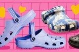 A picture of four Crocs shoes, two purple, one blue and white and one black, on a pink background