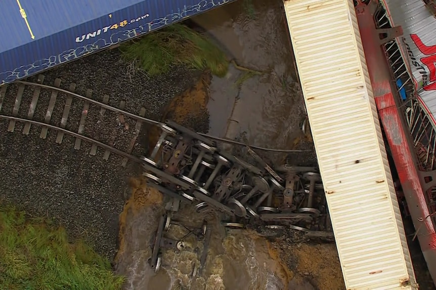 A section of ground underneath the rail track has collapsed and water is running under the collapsed rail line