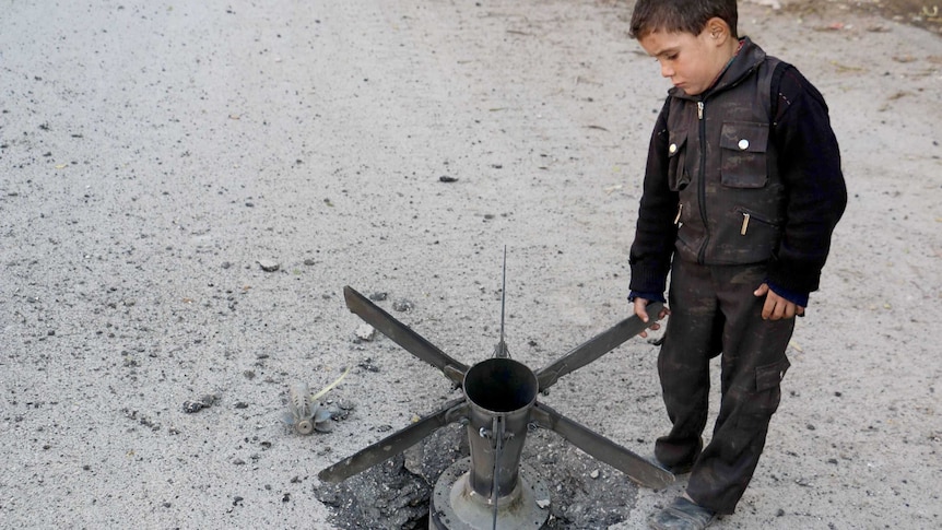 A boy touches a bomb in Syria