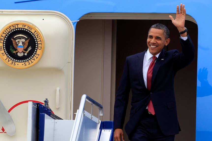 Barack Obama waves upon arriving in Canberra