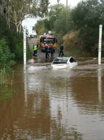 Car stuck in flooded river.