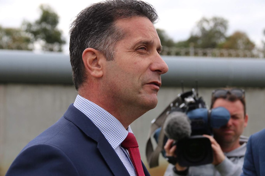 Paul Papalia talks to reporters with a cameraman in the background.
