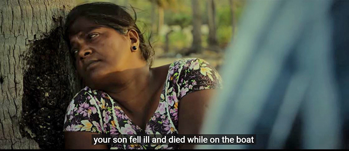 A woman leans against a tree and is told 'your son fell ill and died while on the boat' 
