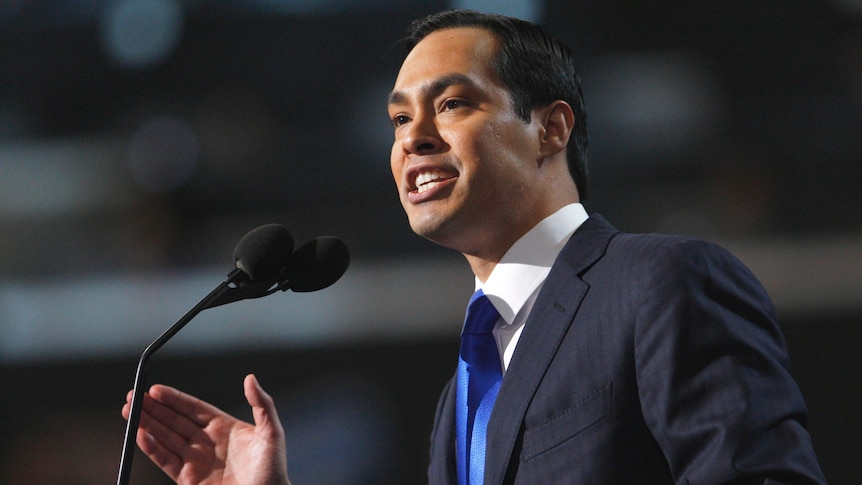 Julian Castro speaks into a microphone while gesturing with his hand.