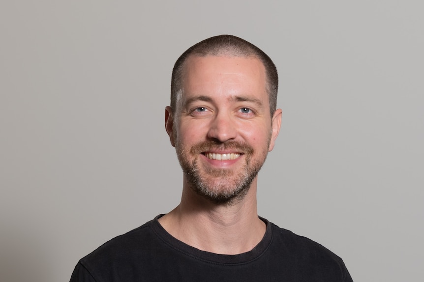 a generic headshot of a man smiling directly at the camera