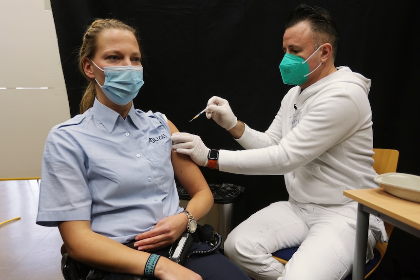 A policewoman gets a booster vaccination against the coronavirus