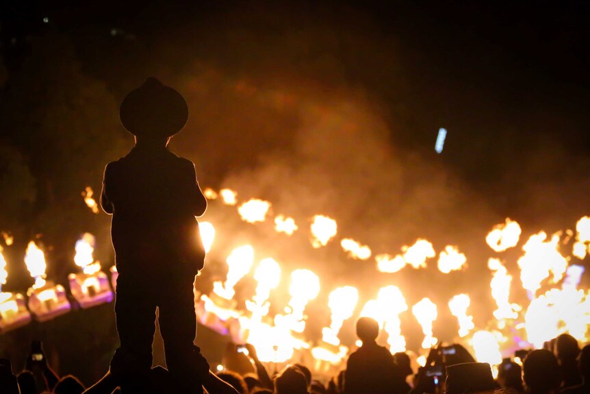 A boy in a hat stands on his dad's shoulders to get a better view of White Night fire show.