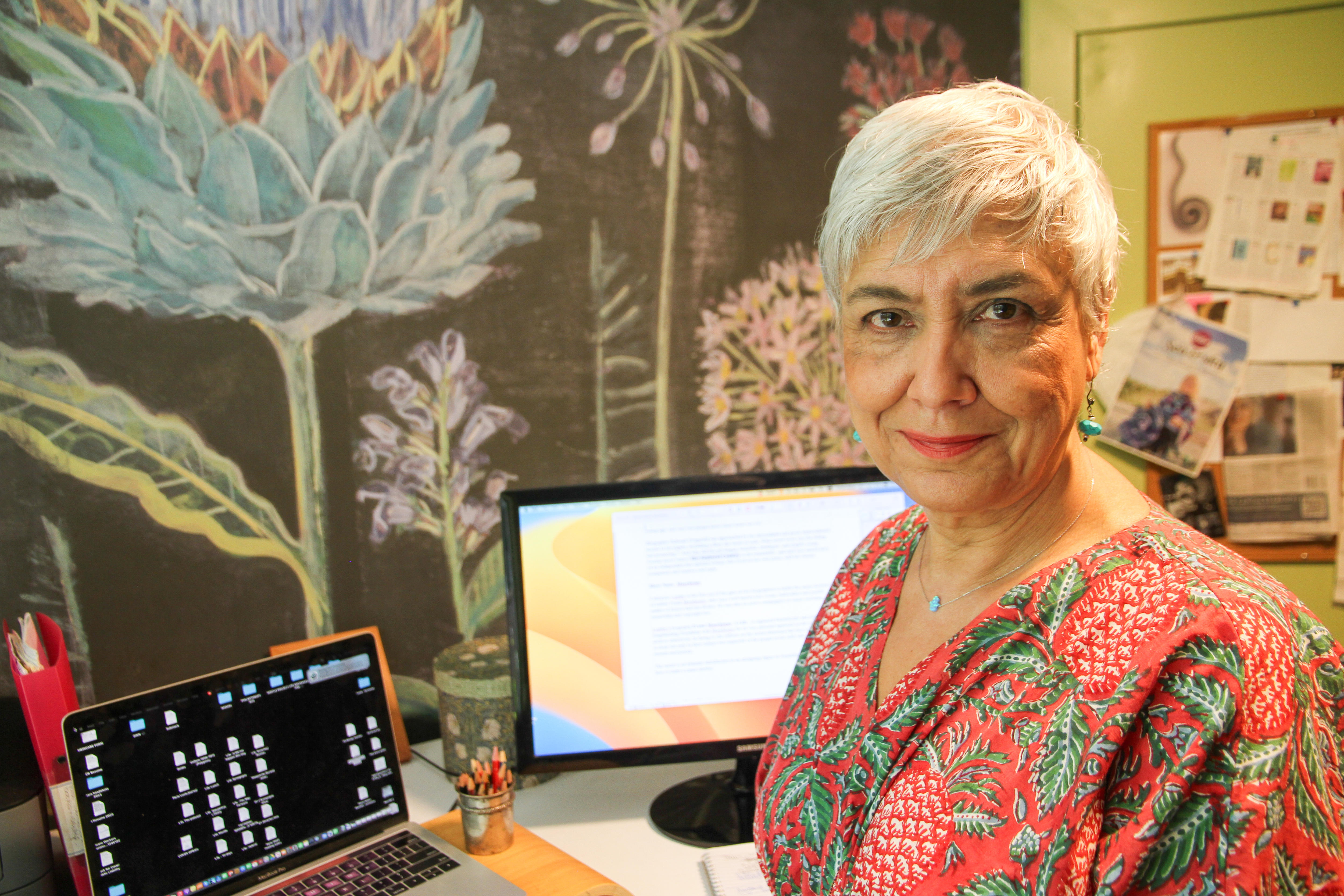 A woman sits in her writing room. 