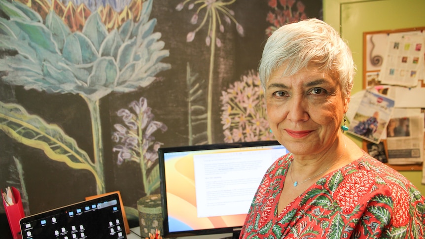 A woman sits in her writing room. 