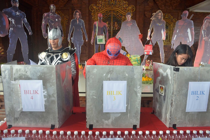 People wear superhero costumes as they vote at a superhero-themed polling station in Indonesia.