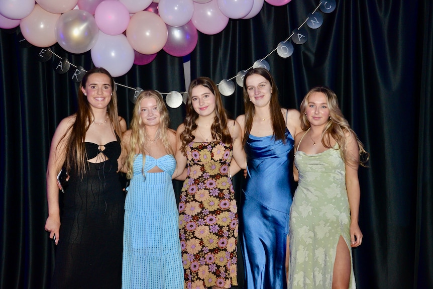 A group of girls dressed well in formal gear, from recycled shops.