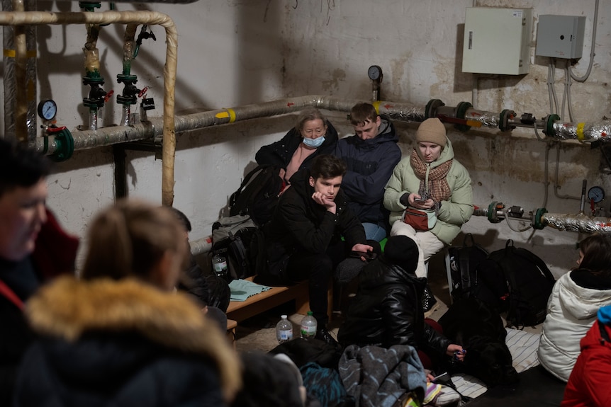 People take shelter at a building basement.
