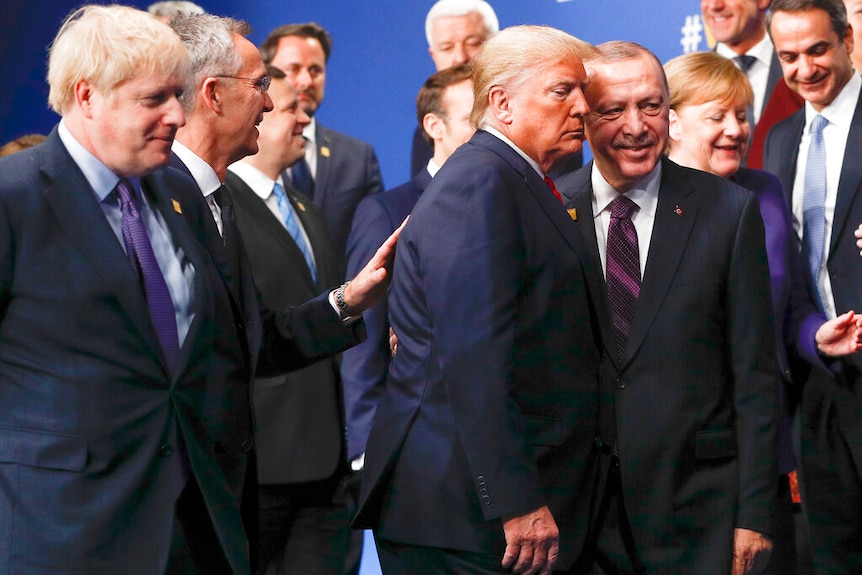 NATO secretary general Jens Stoltengberg is pictured putting his hand on the back of President Trump at a NATO leaders meeting.