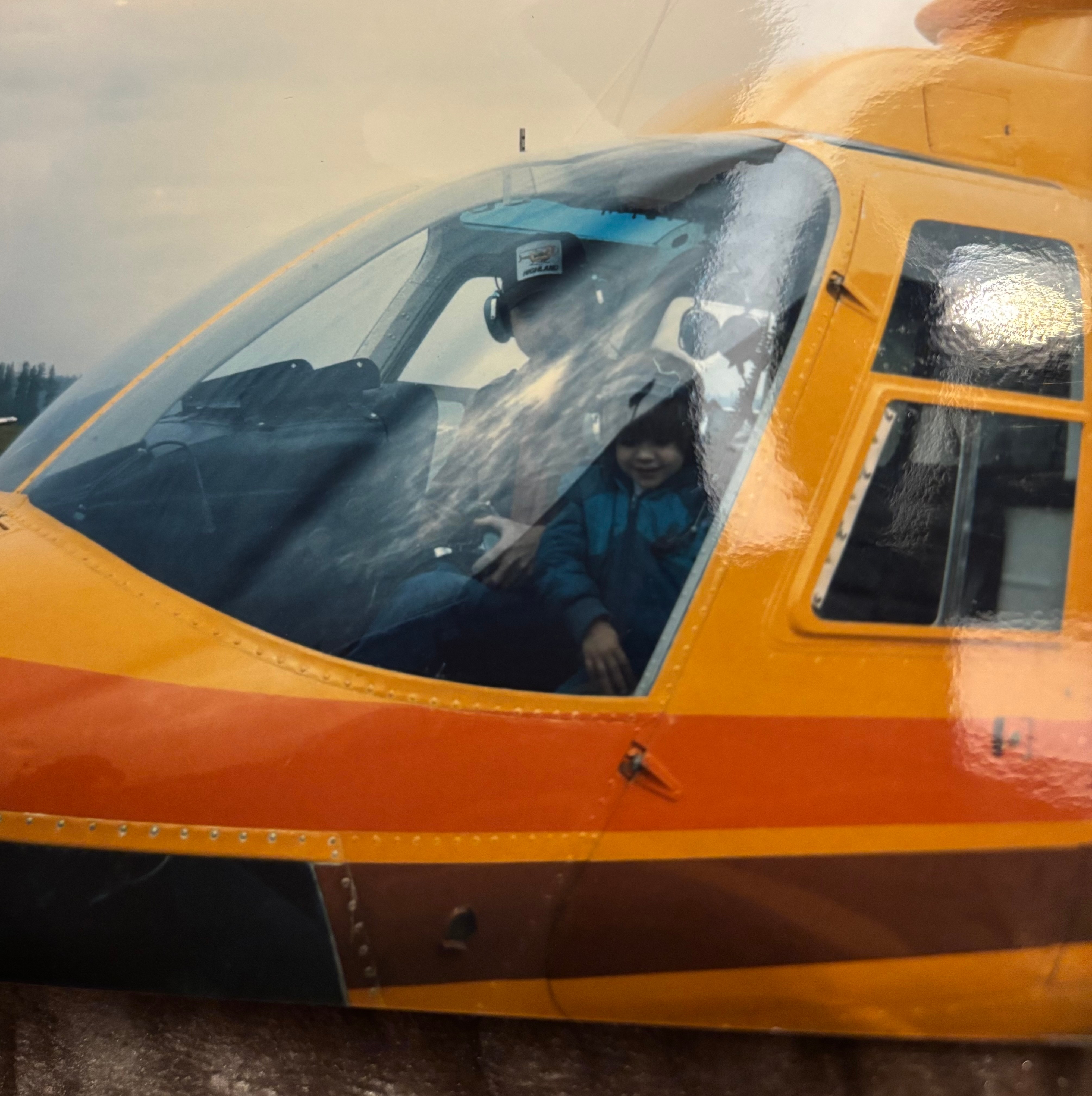 Uma foto de Erin Tassell quando criança em um helicóptero.