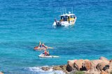 A search boat and two jet skis on the water near rocks at Injidup Beach, south of Yallingup.