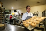 Chan Khun holding a tray of pies.