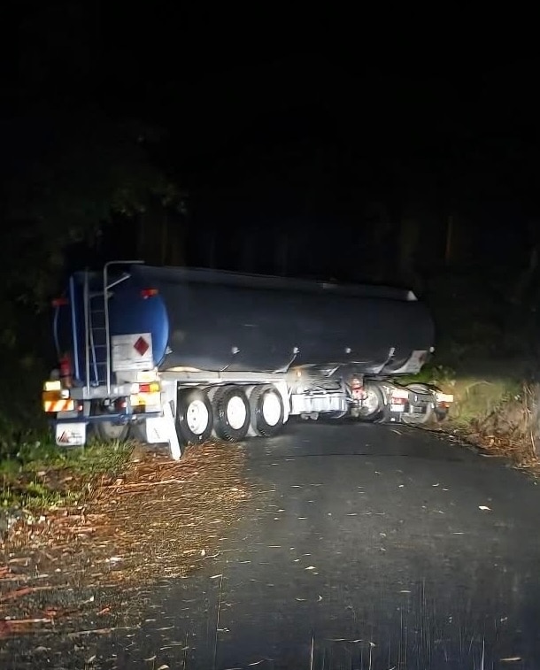 A tanker across a narrow road at night.