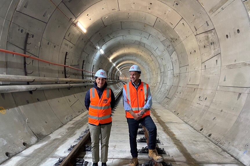 NSW Premier Gladys Berejiklian and Transport Minister Andrew Constance wearing high-vis gear in a Sydney Metro tunnel.