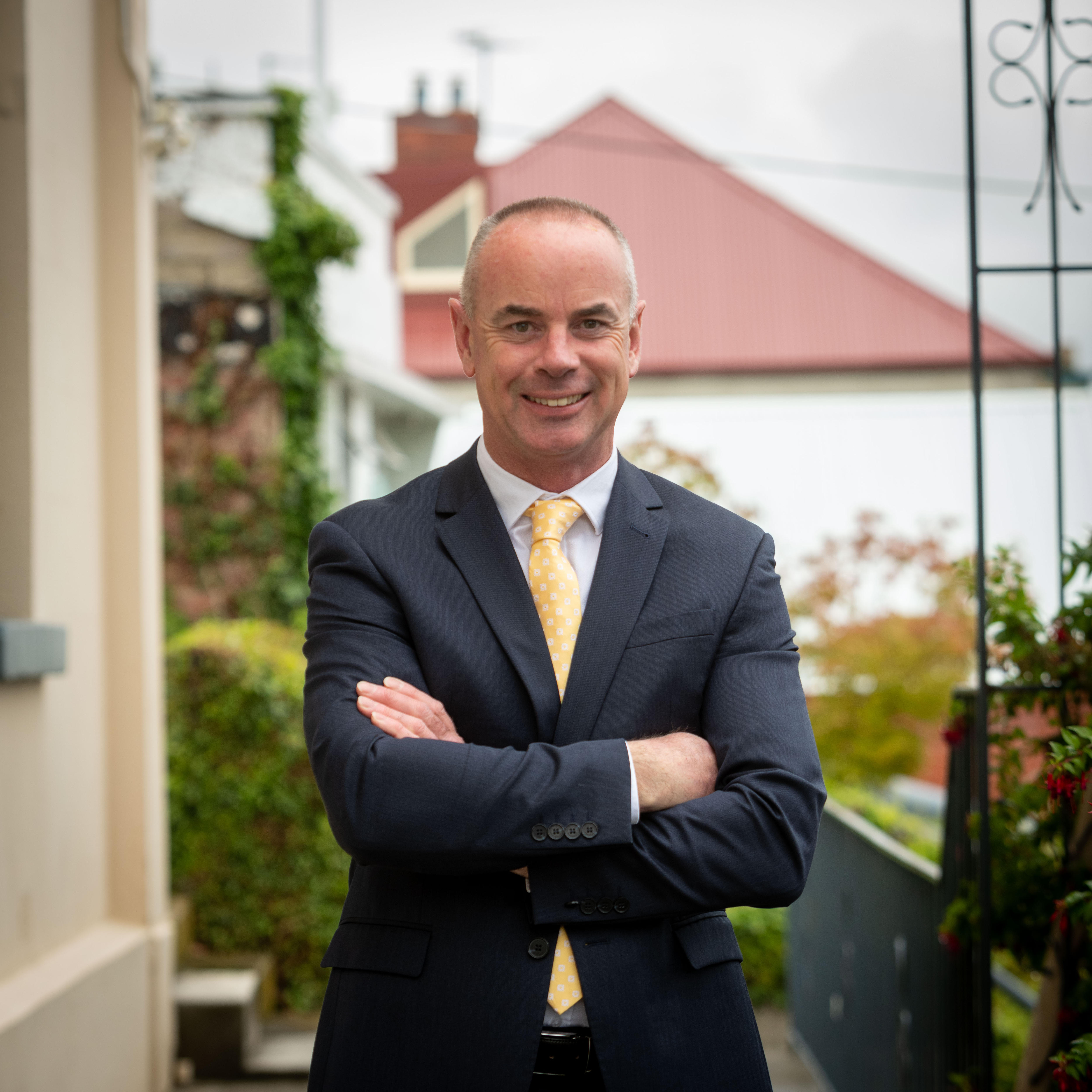 Um homem está na frente de uma casa.
