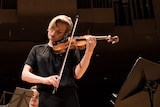 Close up shot of ACO Principal Violin Satu Vänskä playing onstage with a focussed expression.