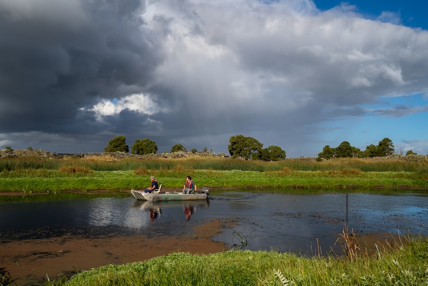 two men in a boat on a lake.