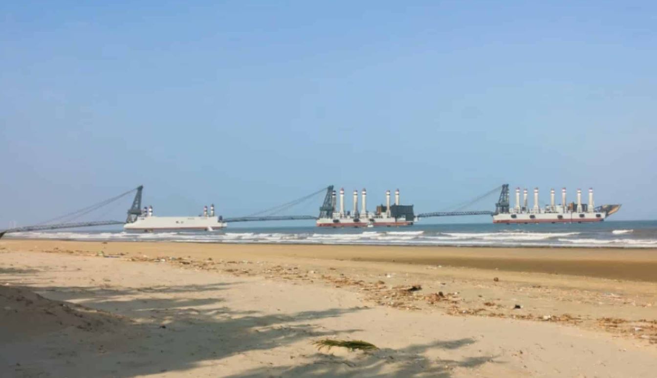A photo taken from a beach in China showing three landing barges connected together and forming one long pier
