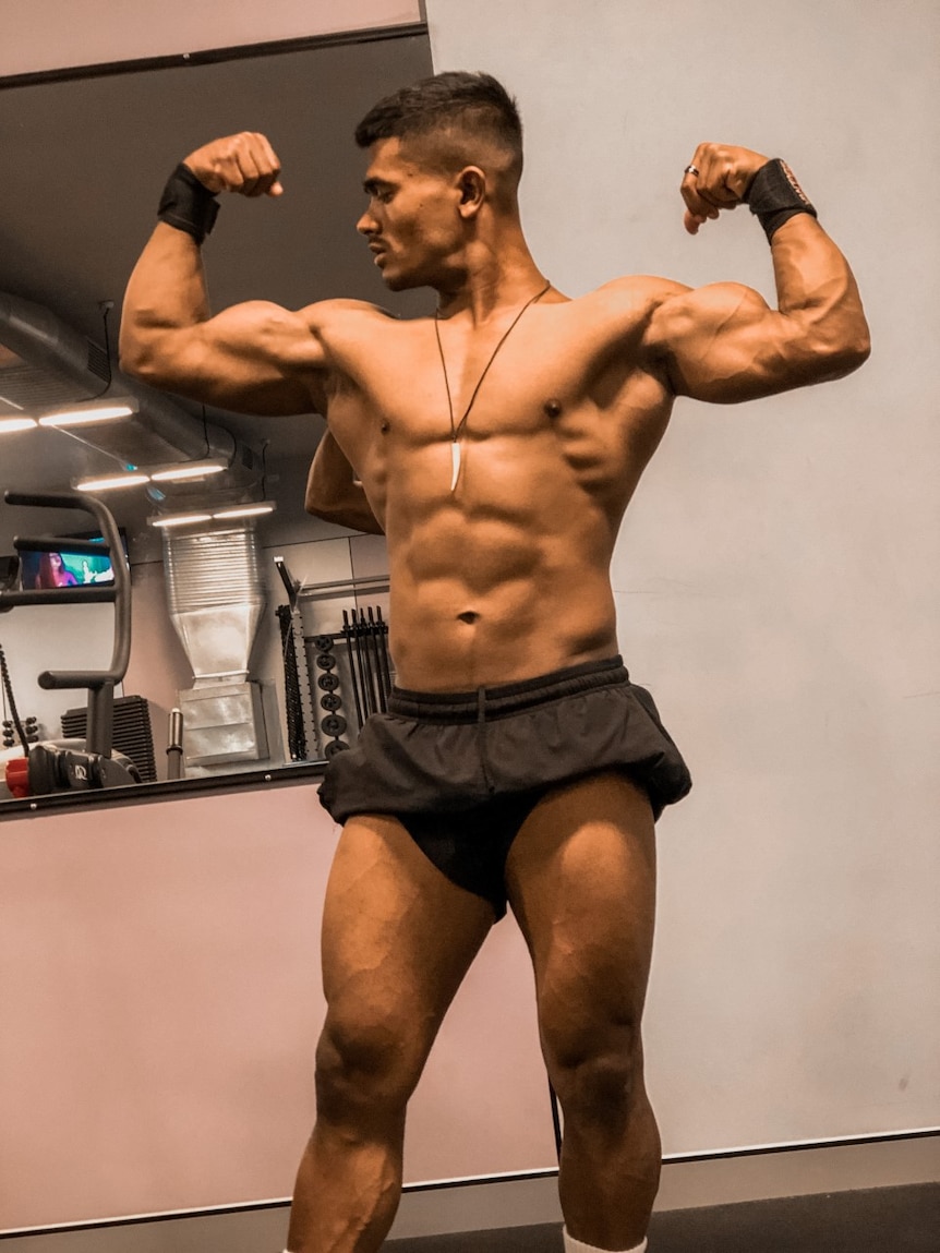 Noor flexes his muscles in the gym.