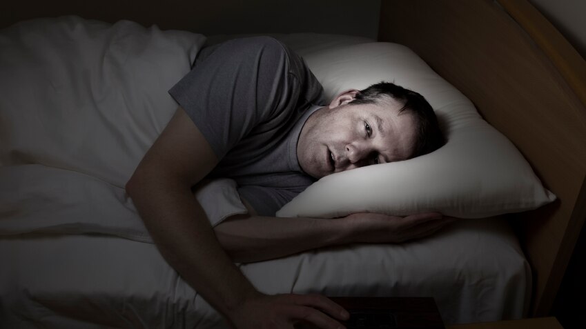 A man lying awake in bed