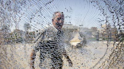 A man looks at shattered windshield of car after bomb attack outside Sunni mosque in Baghdad [File photo].