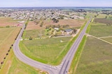 An aerial photo shows one road leading  through the centre of a small town and another going around it, avoiding businesses.