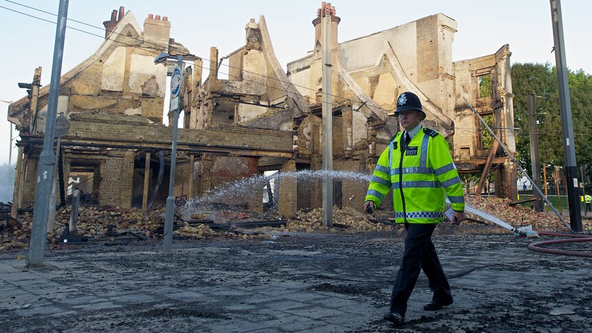 Policeman inspects Croydon riot damage