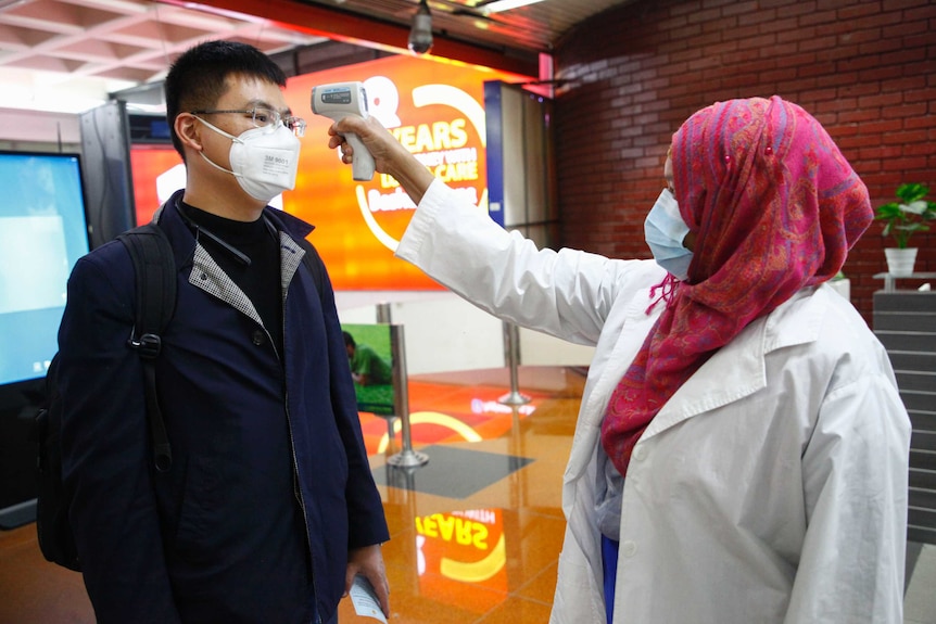 A passenger from Beijing is screened as part of measures to prevent coronavirus infection at Dhaka airport.